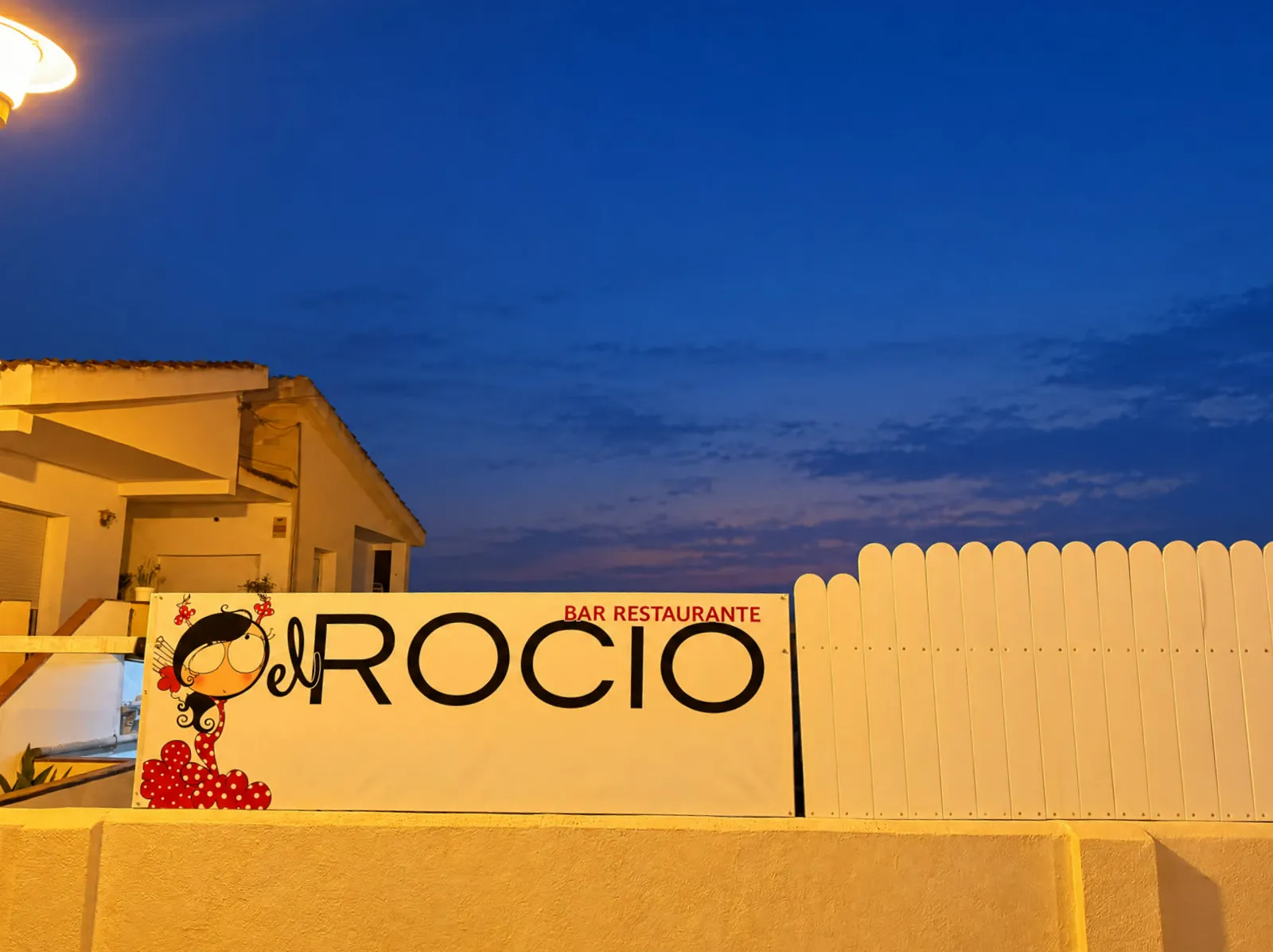 La lona del Bar Restaurante El Rocío al atardecer, en El Vendrell